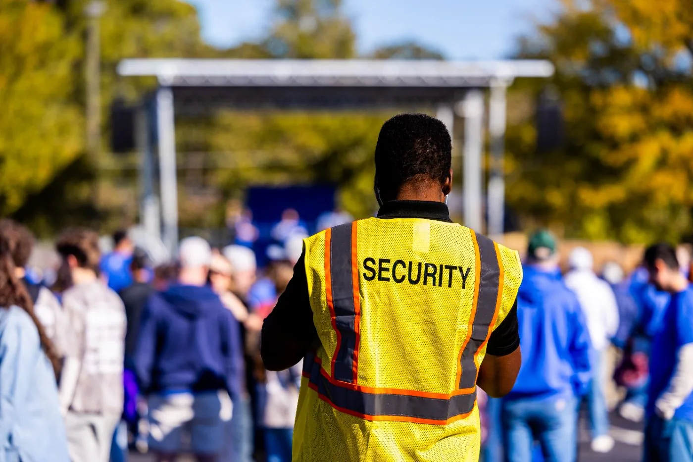 Agent de sécurité en gilet haute visibilité encadrant le public lors d’un événement